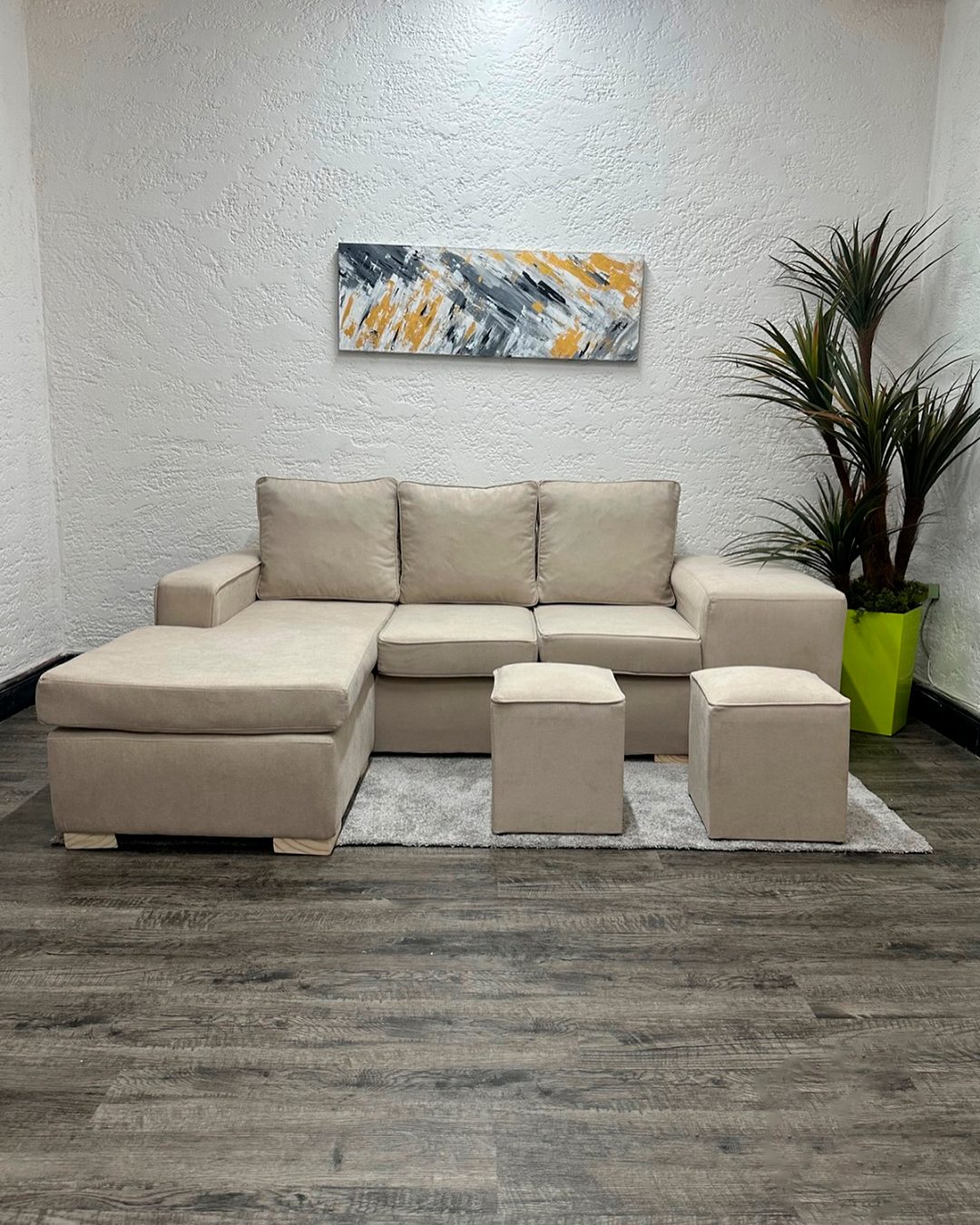 Sofá beige con chaise longue y dos puf
